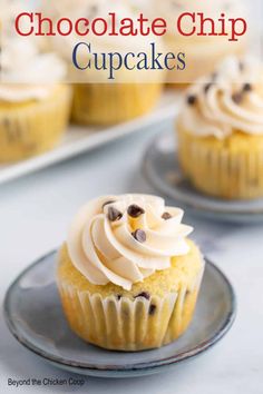 chocolate chip cupcakes with white frosting and chocolate chips in the middle on a plate