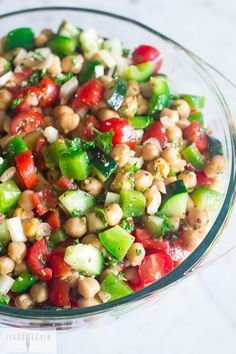 a glass bowl filled with vegetables and chickpeas