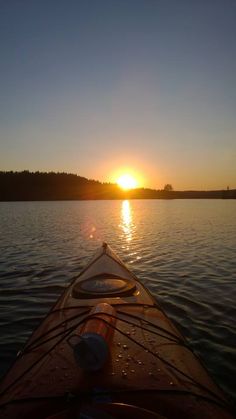 the sun is setting over the water from a kayak