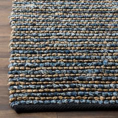 a blue and brown rug on top of a wooden floor