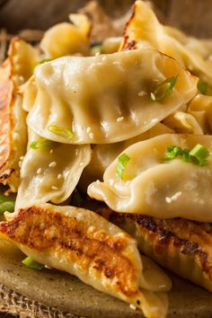 some dumplings are piled on top of each other and garnished with green onions