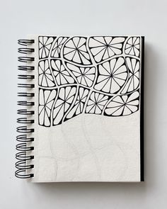 a spiral notebook with black and white designs on it