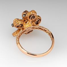 This unique Neda Behnam Couture ring is centered with petal shaped settings accented with rough diamonds and six (6), bezel set, round brilliant cut diamonds. The shoulders of the ring are each accented with twenty-two (22), bead set, round brilliant cut diamonds. The ring measures 20.9mm at the top, rises 11.4mm above the finger, tapering to 2.8mm wide and 1.3mm thick at the base of the shank. Signed Neda Couture. "750 18K y' F454 D037" is stamped on the inside shank. This ring is currently a s Luxury Diamond Cluster Ring With Bezel Setting, Unique Rose Cut Diamond Ring For Formal Occasions, Unique Formal Rose Cut Diamond Ring, Unique Rose Cut Diamond Ring, Unique Formal Diamond Ring With Single Cut Diamonds, Unique Cluster Ring With Rose Cut Diamonds, Unique Bezel Set Diamond Ring, Petal Ring, Bead Set