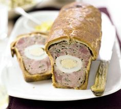 a meatloaf roll on a plate with a knife and fork