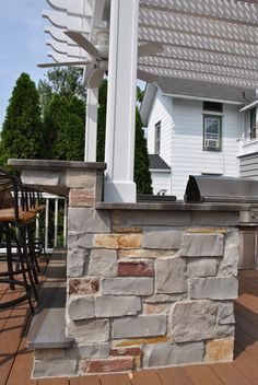 an outdoor kitchen and grill on a deck