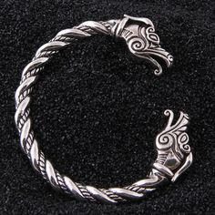 The Viking arm ring is a stunning example of the craftsmanship and attention to detail that was valued in Viking culture. With their intricate designs and powerful symbolism, these bracelets are a true expression of the strength, courage, and resilience of the Viking warriors who wore them, making them a must-have accessory for any collector. Product details: Material: 925 Sterling Silver Weight: 60g One size fits all Free wooden gift box and jewelry bag included Free worldwide shipping Arm Rings, Viking Arm Rings, Dragon Heads, Viking Warriors, Arm Ring, Viking Culture, Dragon Bracelet, Viking Bracelet, Dragon Head