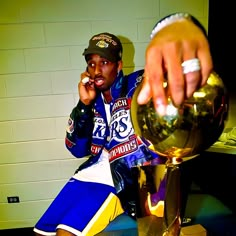 a man sitting on a bench next to a trophy