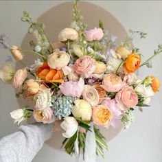 a white vase filled with lots of different colored flowers