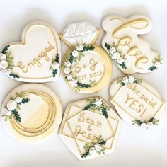 decorated cookies are arranged in the shape of heart and wedding rings with names on them