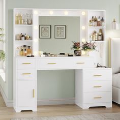 a white vanity with lights on it in front of a mirror and couch next to a window