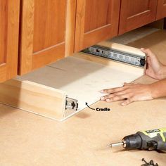 a woman is working on the drawer in her kitchen, with tools and screwdrivers