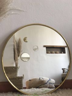 a round mirror sitting on top of a white rug