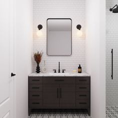 a bathroom with black and white tile flooring and a large mirror above the sink