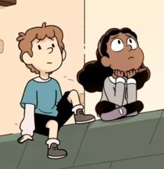 a boy sitting on the ground next to another person