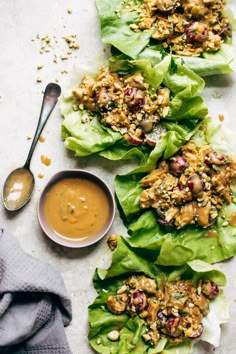 lettuce cups filled with meat and sauce on top of a white tablecloth