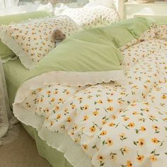 an unmade bed with yellow flowers and green sheets on it's headboard