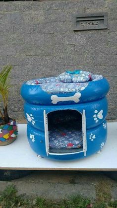 an inflatable dog kennel with its door open next to a potted plant