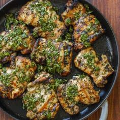 chicken with herbs in a skillet on a wooden table