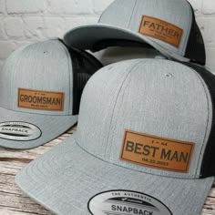 two gray hats with brown leather patching on the front and back, one for father's day