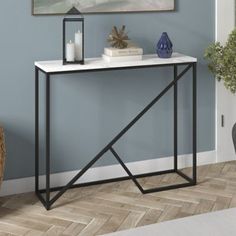 a white marble top console table with black metal legs and an open shelf on the side