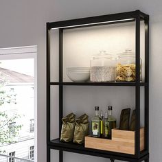 a shelf with some bottles and bags on it next to a window in a room