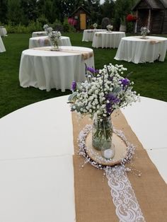 a vase filled with flowers sitting on top of a table covered in burlocks