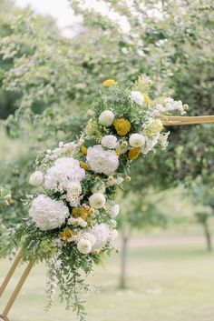 a wedding arch with flowers and greenery on the side for an outdoor ceremony or reception