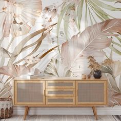 a wallpapered room with tropical leaves and plants on the walls, along with a sideboard