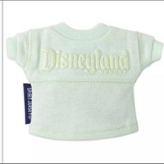 a white dog sweater with the word disneyland on it's chest and an embroidered logo