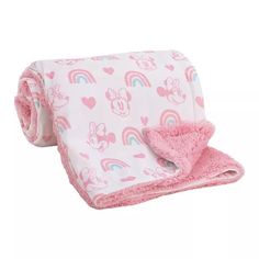 a pink blanket with mickey mouse and rainbows on the front, it is folded up