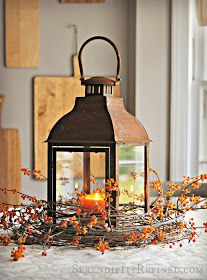 an old lantern is sitting on the table with some berries and oranges around it