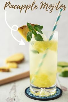 a pineapple mojito with mint garnish in a tall glass on a blue and white plate