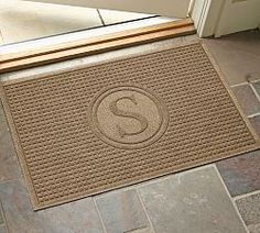 a door mat that has the letter s on it in front of a door with a glass window