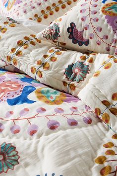 the comforter is made up with colorful flowers and leaves on it's edges