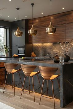 a kitchen with marble counter tops and wooden stools in front of an island that has gold pendant lights hanging from the ceiling