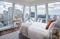 a bedroom with large windows overlooking the city