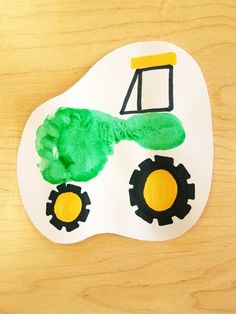 a paper plate with a handprinted tractor on it and the shape of a mask