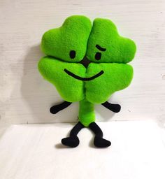 a green stuffed animal with two hearts on it's back