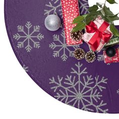 presents wrapped in red and white paper on a purple tablecloth with snowflakes