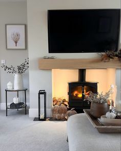 a living room filled with furniture and a flat screen tv mounted on the wall above a fire place