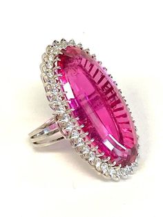 Platinum Pink Tourmaline & Diamond Cocktail Ring DescriptionPlatinum Ring; 1 Oval Pink Tourmaline 31.11 Carat; 37 Round Brilliant Cut Diamonds 1.48 Carat Total Weight, SI-1, I-J; Finger Size 5 1/2; 19.7 Grams. #BarbieRing#Barbie#BarbiePink Payment All payments must be made through PayPal, NO EXCEPTIONS. We cannot accept payment plans. We do not offer Layaway. Shipping We ship via USPS Registered Mail, Return Receipt in order to provide tracking and insured delivery, which usually takes 5-7 days Party Rings In White Gold With Gemstone, Party White Gold Gemstone Rings, Formal Pink Ring With Bezel Setting, Formal Pink Rings With Bezel Setting, White Gold Gemstone Rings For Party, Dazzling Oval Rings For Party, Oval Party Ring With Center Stone, Pink Oval Rings For Party, Formal Pink Rings With Polished Finish