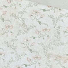 the fabric has pink flowers and green leaves on it