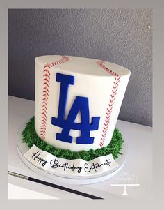 a baseball themed birthday cake with the number 4 on it's top and green grass