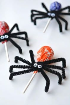 three spider lollipops are sitting on top of each other with candies in them