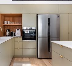 a modern kitchen with stainless steel appliances and wood cabinets