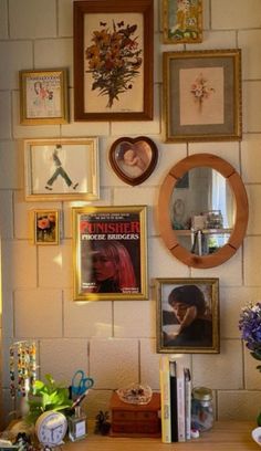 there are many framed pictures on the wall with flowers in vases next to them