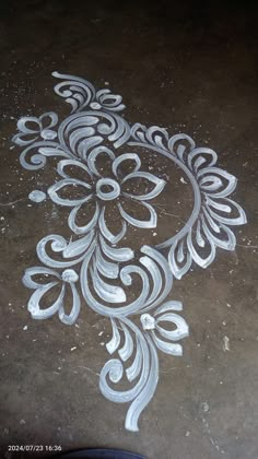 an intricately designed design on the ground with white paint and silver flecks