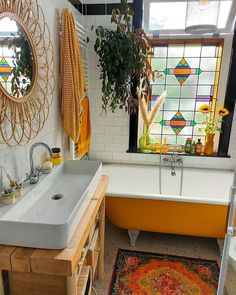 a bath room with a sink and a bath tub next to a window in it