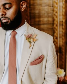 a man in a suit and tie with flowers on his lapel