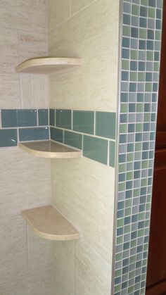 the corner shelves in this bathroom are made out of wood and glass tiles, along with blue tile